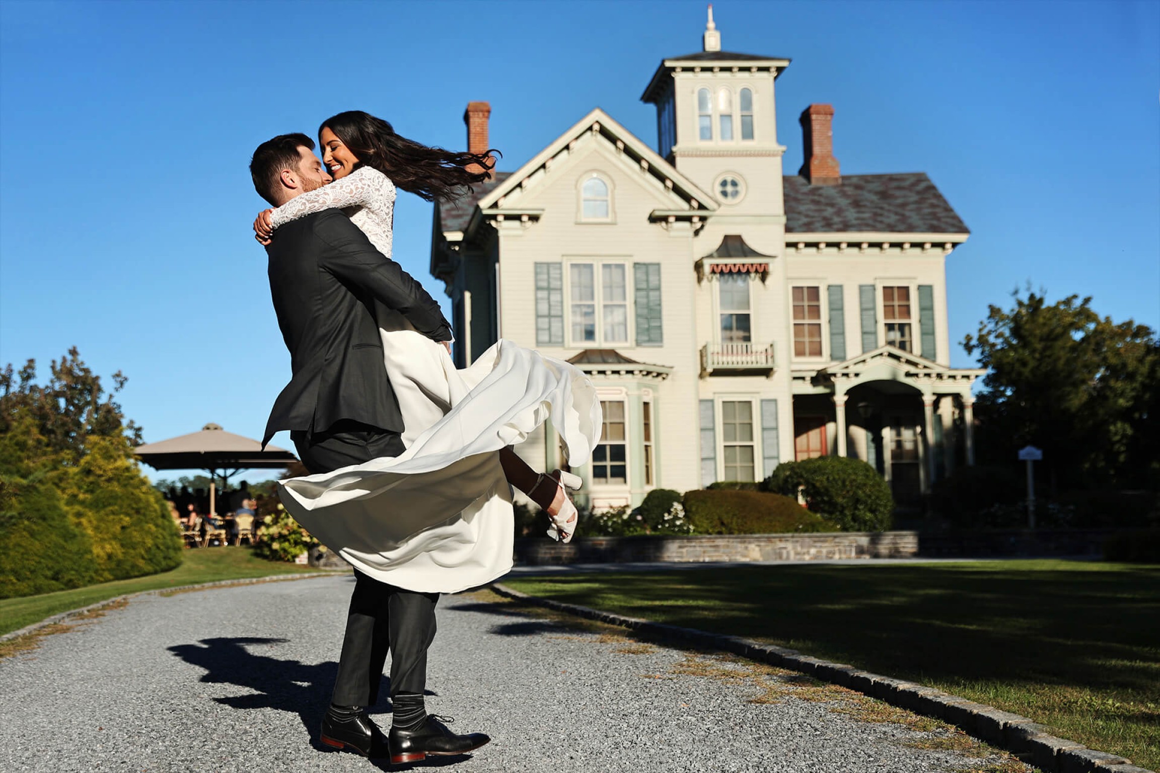 Bride jumping on the Groom in front of Jedediah Hawkins Inn - 3 Elements Photography-